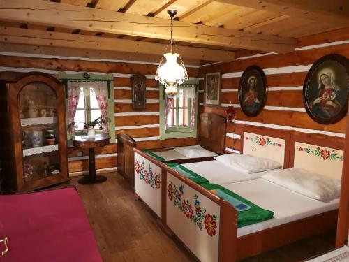 a bedroom with two beds in a log cabin at Chalupa Peter in Liptovský Michal