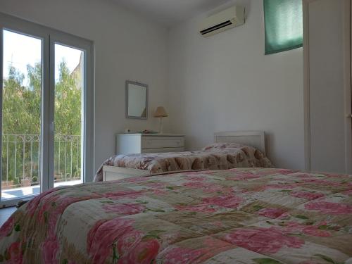 a bedroom with two beds and a large window at Da Raff in Lacco Ameno