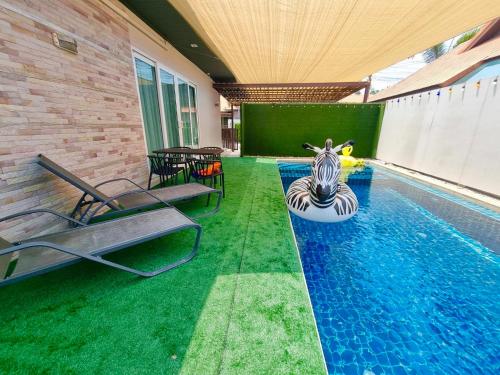 a swimming pool with a zebra in the middle of it at Midas Pool Villa in Jomtien Beach