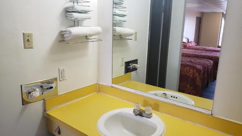 een badkamer met een wastafel en een spiegel bij West Texas Inn & Suites Midland in Midland