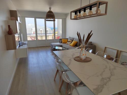 a kitchen and living room with a table and chairs at Ker Romain - Sea View - 3 bedrooms Appt in Saint Malo
