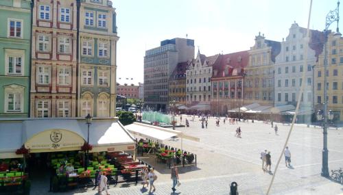 a group of people walking around a market in a city at Happy Apartments - Economy in Wrocław