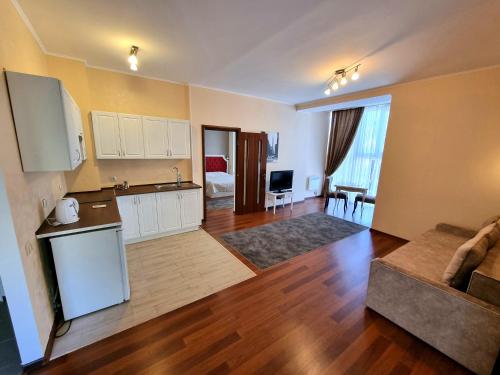 eine Küche und ein Wohnzimmer mit einem Sofa und einem Tisch in der Unterkunft Helen Hotel in Mykolajiw