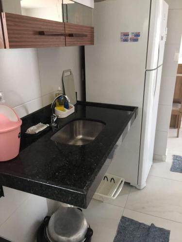 a kitchen counter with a sink and a refrigerator at Lindo apartamento de férias à 100m do mar! in Cabedelo