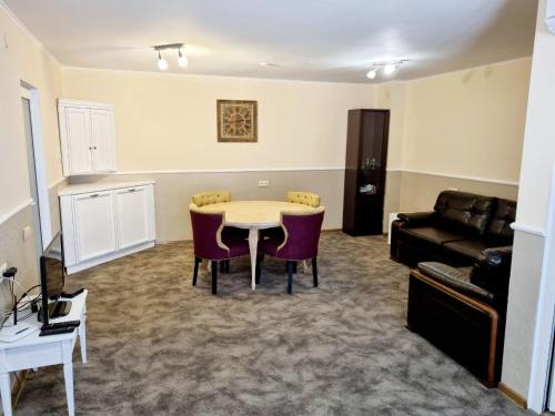 a living room with a table and chairs and a couch at Helen Hotel in Mykolaiv