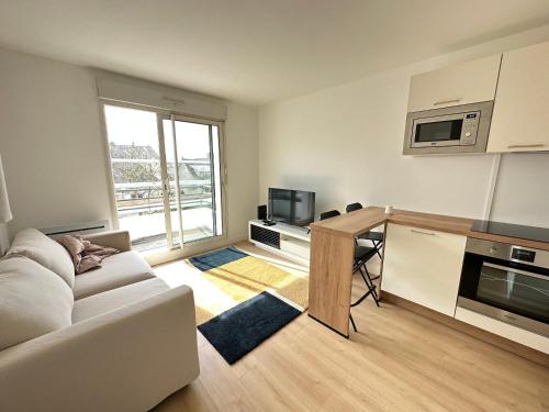 a living room with a white couch and a table at Appartement Caen in Caen
