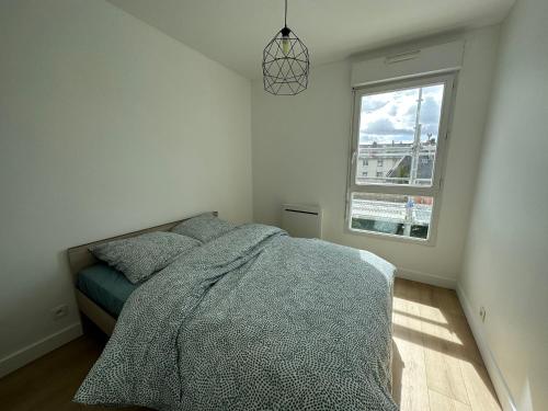 une chambre avec un lit et une fenêtre dans l'établissement Appartement Caen, à Caen