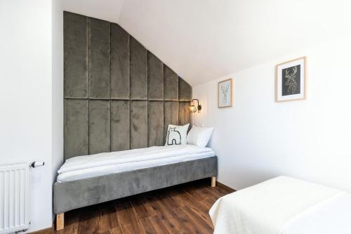a bedroom with a bed and a wall at Rozewie Apart in Jastrzębia Góra