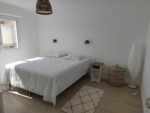 une chambre blanche avec un lit et une fenêtre dans l'établissement Ker Romain - Sea View - 3 bedrooms Appt, à Saint-Malo