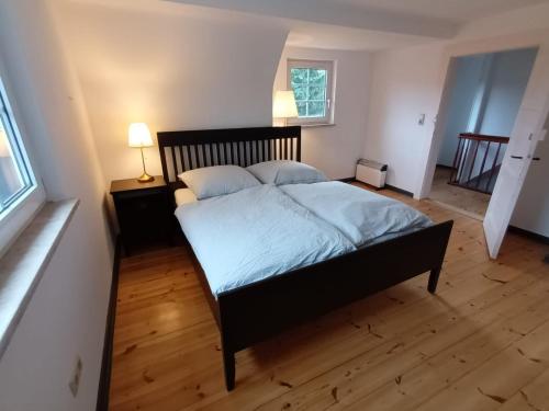 a bedroom with a large bed and a wooden floor at Ferienhaus Naturparadies Rhön in Willmars