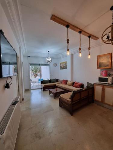 duży salon z kanapami i telewizorem w obiekcie Appartement vue mer w mieście Mahdia