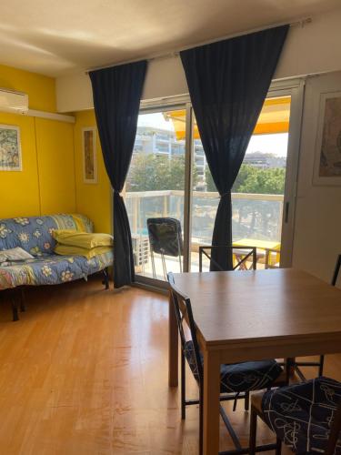 un salon avec une table et un canapé dans l'établissement appartement bord de mer avec piscine, à Cagnes-sur-Mer