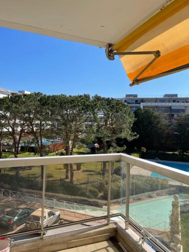 - un balcon avec vue sur une voiture et une piscine dans l'établissement appartement bord de mer avec piscine, à Cagnes-sur-Mer