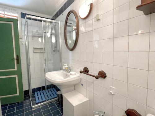 ein weißes Badezimmer mit einem Waschbecken und einem Spiegel in der Unterkunft Forte 43 in Forte dei Marmi