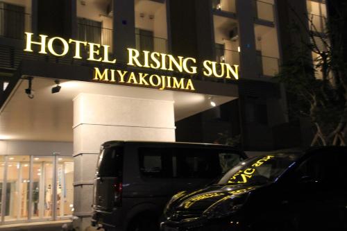 un camion parcheggiato di fronte a un cartello del sole che sorge in un hotel di Hotel Risingsun Miyakojima a Miyakojima