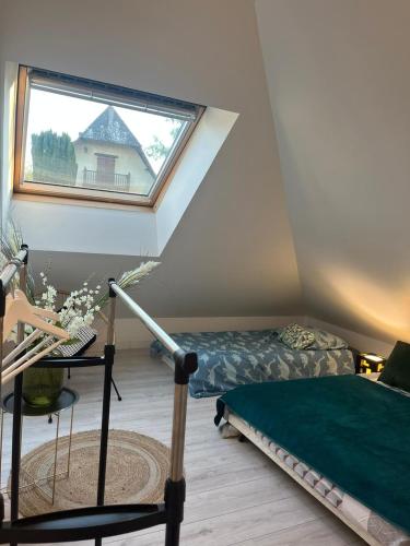 une chambre mansardée avec deux lits et une fenêtre dans l'établissement Magnifique logement, confortable et paisible., à Saint-Marcel