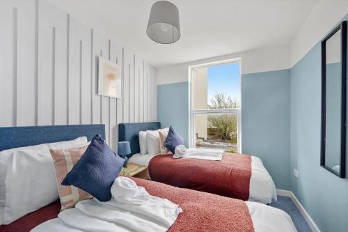 1 dormitorio con 2 camas y ventana en The Exquisite Gem of Central Bristol - Sleeps 18 en Bristol