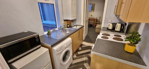a kitchen with a sink and a washing machine at 12 Minutes to Centre-Near A1-Parking in Swalwell