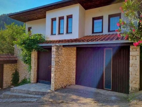 una casa con dos puertas de garaje delante de ella en Villa Tajra Stolac, en Stolac