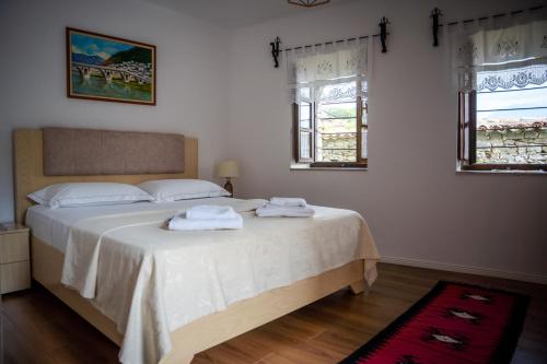 a bedroom with a bed with two towels on it at Hotel Borklad in Berat