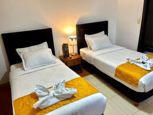 sypialnia z 2 łóżkami z białą pościelą i łukami w obiekcie House Studio Hotel w mieście Bogota