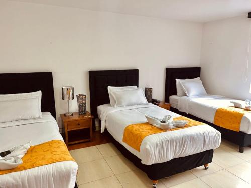 a hotel room with two beds with towels on them at House Studio Hotel in Bogotá