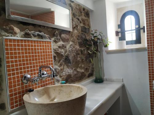 a bathroom with a sink and a mirror at xenios Z rustic rural cottage in Karídhion