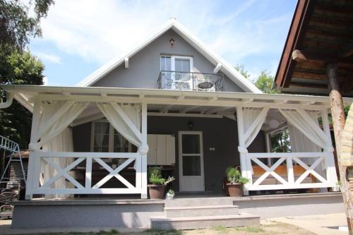 Dieses weiße Haus verfügt über eine Veranda und einen Balkon. in der Unterkunft Palić vila Maša pr Emina Stipancevic in Palić