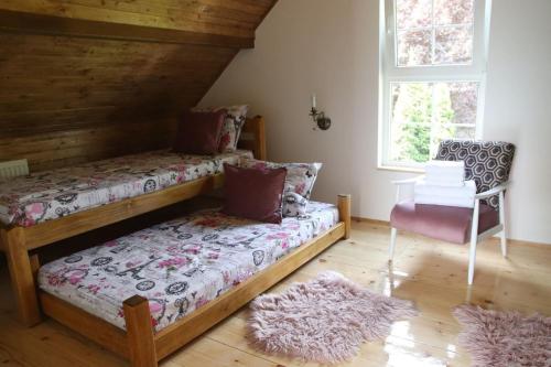 a bedroom with two bunk beds and a chair at Palić vila Maša pr Emina Stipancevic in Palić