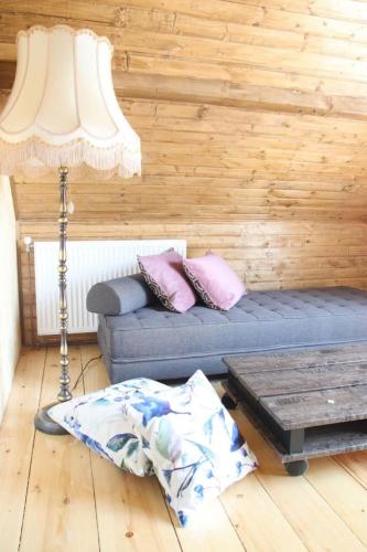 a living room with a blue couch and a lamp at Palić vila Maša pr Emina Stipancevic in Palić