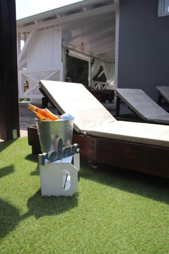 a bed and a bucket on the grass next to a house at Palić vila Maša pr Emina Stipancevic in Palić