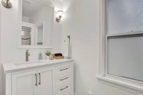 bagno bianco con lavandino e specchio di Relaxing Retreat Near Blossom & CVNP a Hudson