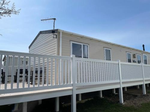 a mobile home with a white fence on a bridge at Emma's Oasis 4-bedroom caravan at Durdle Door in West Lulworth