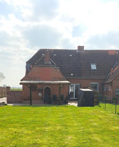 a brick house with a lawn in front of it at Deichstube-Greetsiel in Krummhörn