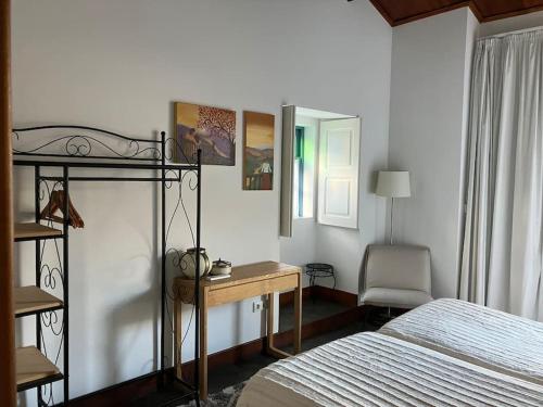 a bedroom with a bed and a desk next to a bed at casa das ameias in Folgosa