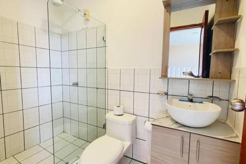 a bathroom with a shower and a toilet and a sink at Amplio departamento con garage y cerca al Shopping in Santo Domingo de los Colorados