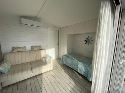 een slaapkamer met een bank en een bed erin bij Casa vacanza in Sabaudia