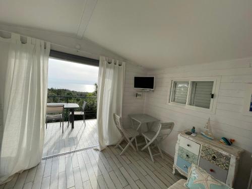 Casa vacanza في ساباوديا: غرفة معيشة مع شرفة مع طاولة وتلفزيون