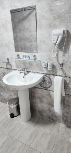 a bathroom with a sink and a mirror at AMIRSHOX GUEST HOUSE in Samarkand