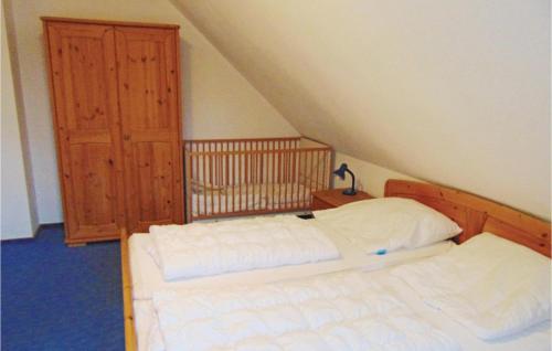 ドルム・ノイフェルトにあるAmazing Home In Wurster Nordseekste With 3 Bedrooms And Wifiのベッドルーム1室(ベッド2台、木製キャビネット付)