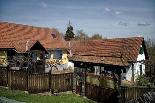una casa con una valla de madera delante de ella en Stilvolles Landhaus im Dreiländereck, en Felsőszölnök
