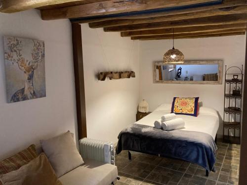 - une chambre avec un lit, un canapé et une chaise dans l'établissement Bellavieja, à Villavieja del Lozoya