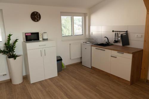 a kitchen with white cabinets and a microwave at Apartmány Močovice in Močovice