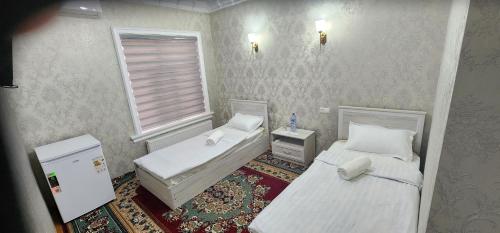 ein kleines Zimmer mit 2 Betten und einem Fenster in der Unterkunft AMIRSHOX GUEST HOUSE in Samarkand