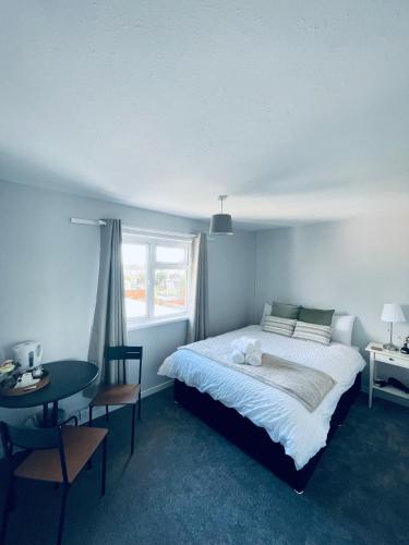 a bedroom with a bed and a table and a window at cozy room Shared House in Bristol