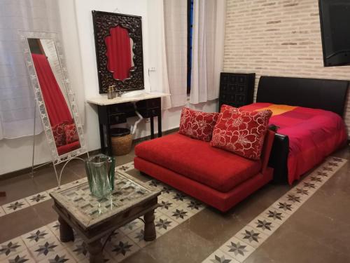 a living room with a red couch and a table at rincones con encanto 