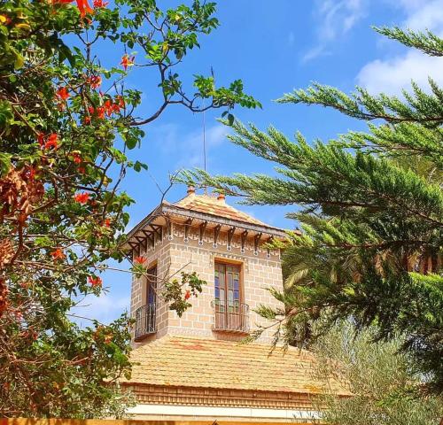 a brick building with windows and trees in the foreground at rincones con encanto 