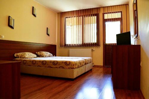 1 dormitorio con 1 cama y TV en Хотел Ажур, en Kotel