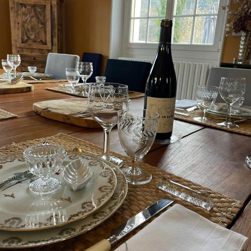 - une table avec une bouteille de vin et des verres dans l'établissement La Bigourdane, à Gerde