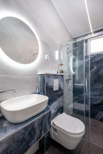 a bathroom with a sink and a toilet and a mirror at Villa Laura in Mlini